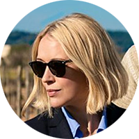 a blonde woman in sunglasses looking down and to the left